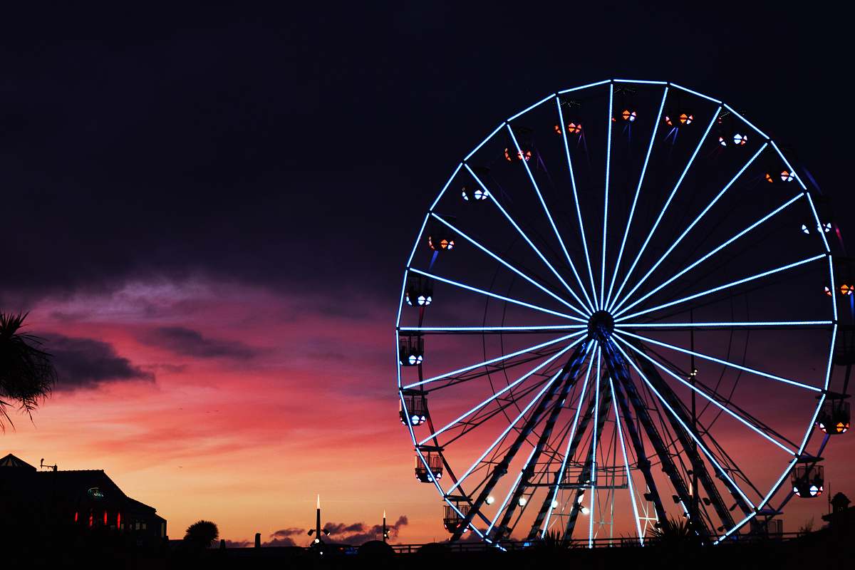ferris wheel silhouette photography of lit-up ferris wheel during golden hour amusement park